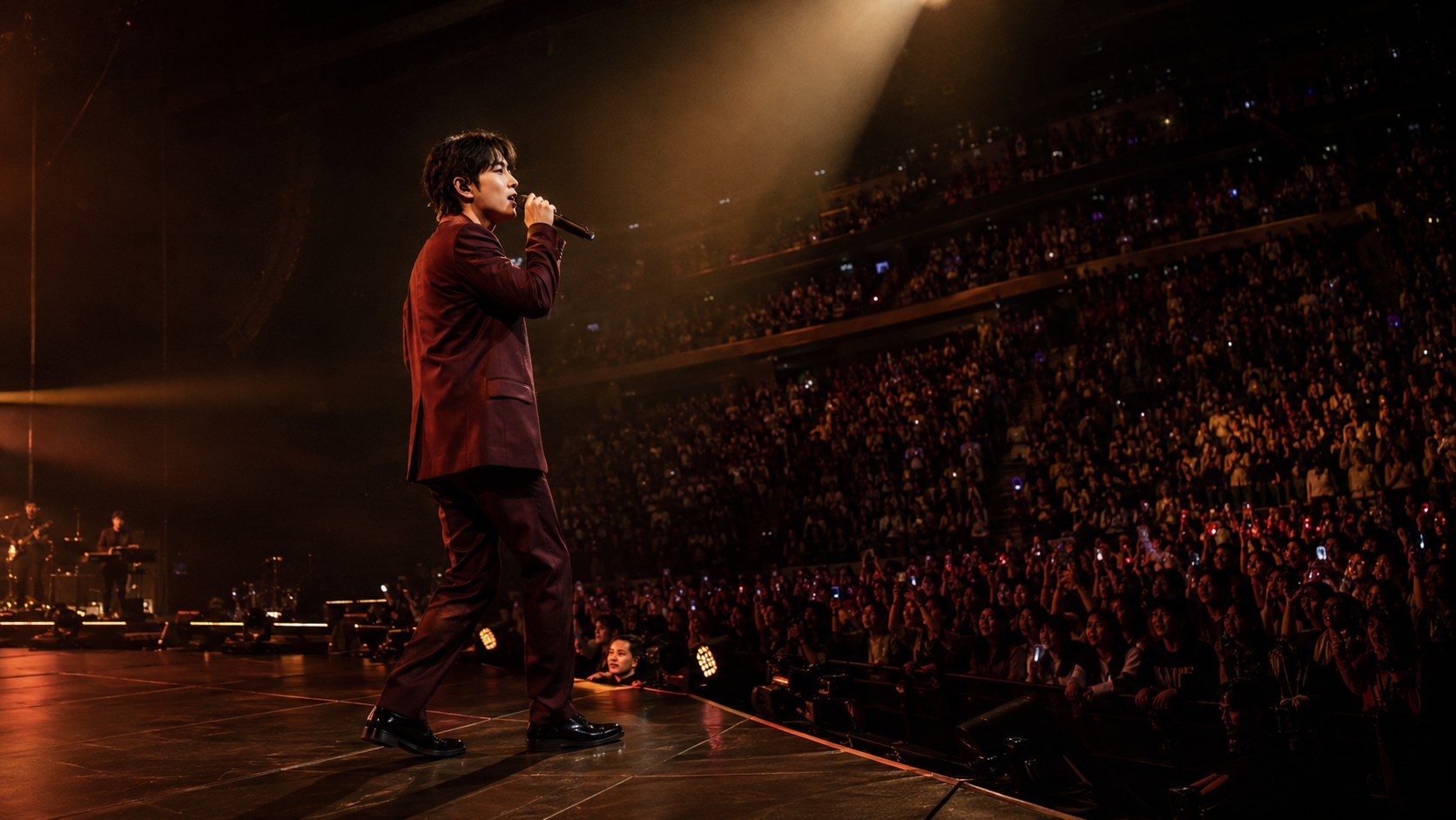 The same Icon singing into a microphone for a live concert audience